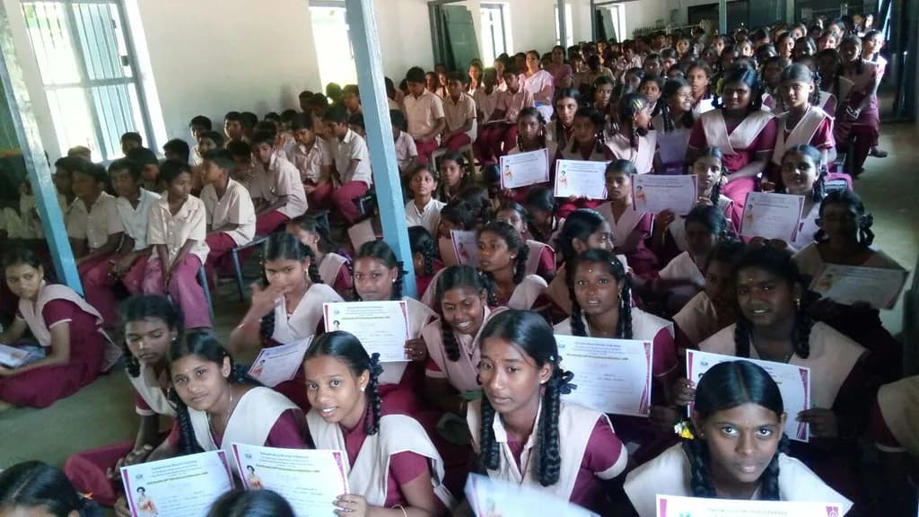 கரும்பலகையுடன் வகுப்பறையில் அமர்ந்திருக்கும் மாணவர்கள்